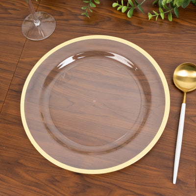 Clear glass plate with a gold rim on a wooden table.