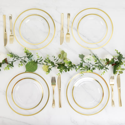 Elegant dining setup with gold-accented plates and cutlery on a marble surface.