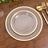 Elegant glass plate with gold rim on wooden table setting.