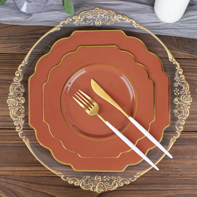 Elegant dinnerware set with gold accents and flatware on a wooden table.