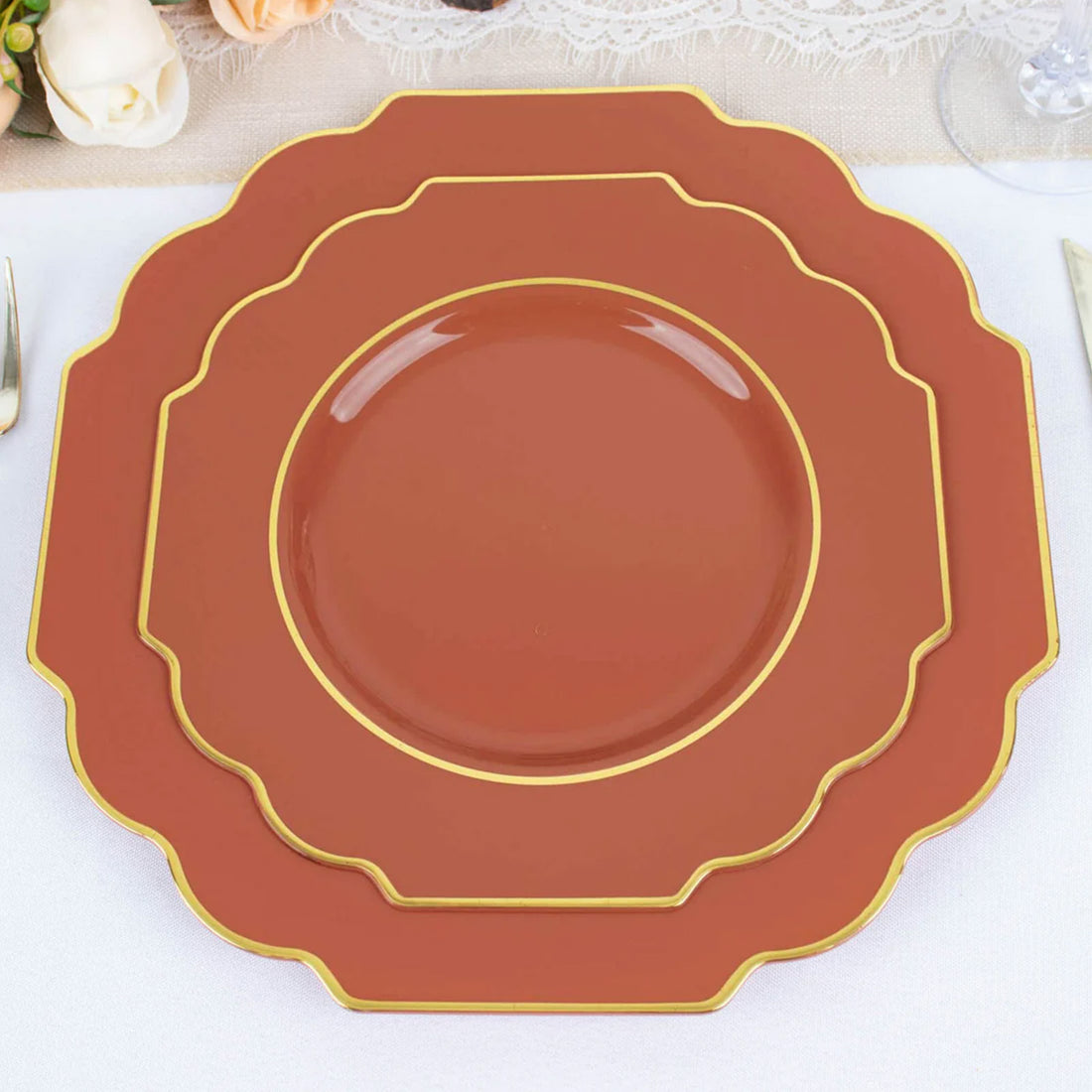 Elegant terracotta plates with gold trim in layered design.