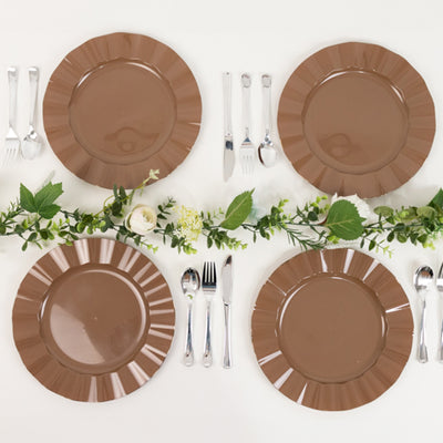Brown decorative plates set with cutlery and greenery arrangement.