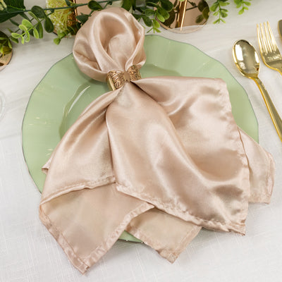 Silk napkin elegantly draped on a pastel plate with golden cutlery.