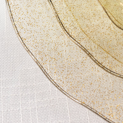 Gold-flecked transparent decorative plates on a white background