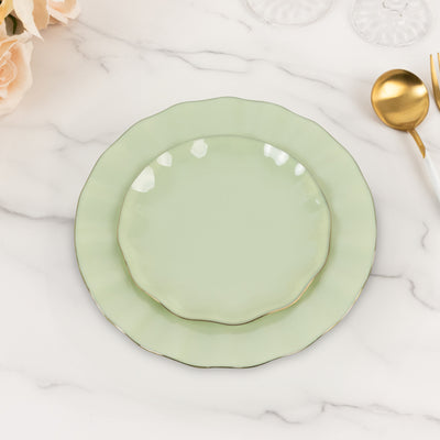 Green scalloped dinner and salad plates stacked on a marble surface.