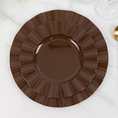 Brown fluted dinner plates stacked on a marble surface.