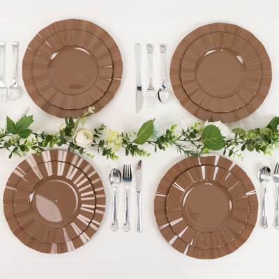 Brown decorative plates arranged elegantly with cutlery and greenery.