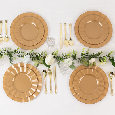 Elegant gold-rimmed plates set on a table with greenery and cutlery.