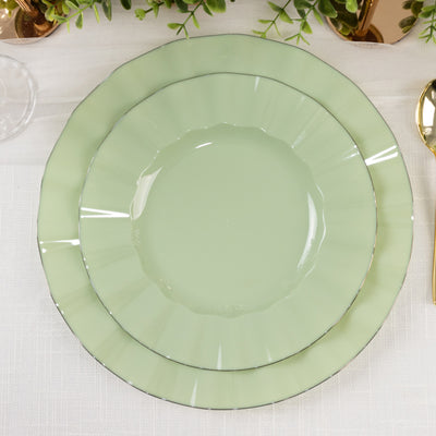 Set of three elegant green plates with a silver rim on a textured tablecloth.