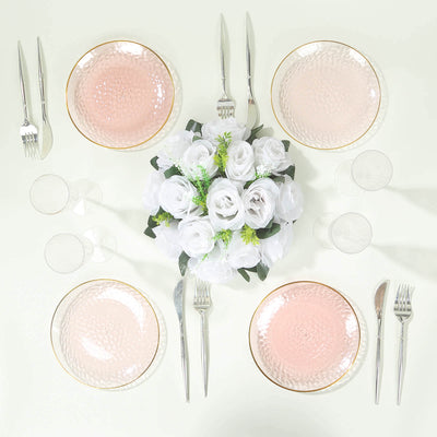 Elegant pink dessert plates with gold rims arranged around a floral centerpiece.