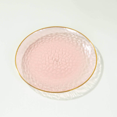 Pink glass plate with a textured surface and gold rim