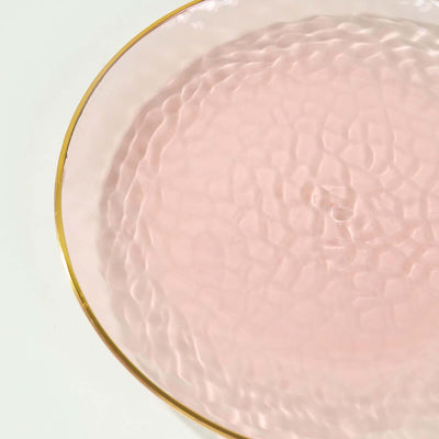 Pink textured plate with gold rim on a white background.