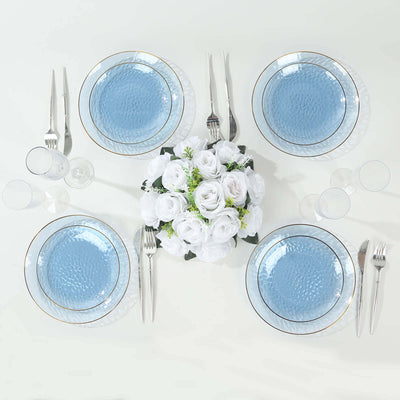Elegant blue dinner plates with floral centerpiece on a white table setting.
