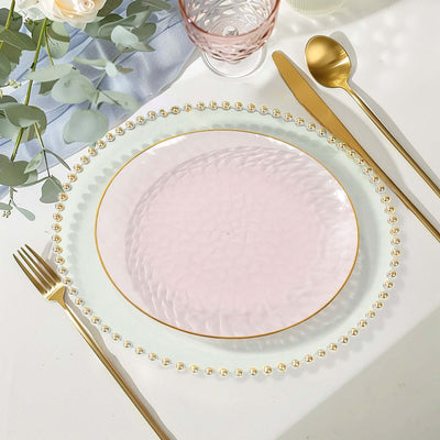 Elegant pink glass plate with gold rim and beaded edge, styled on a table setting.