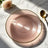 Pink spiral-patterned plate with a gold rim on a marble surface.