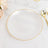 Elegant white plate with gold rim on marble surface.