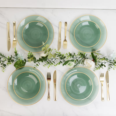 Elegant green plates with gold trim arranged on a marble table setting.