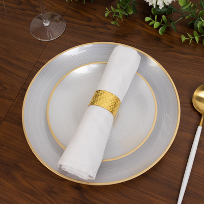 Elegant dining plate with a white napkin and gold accent on a wooden table.