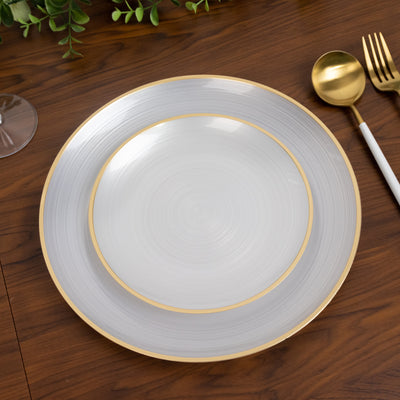 Elegant white and gold dinner plates set on a wooden table.
