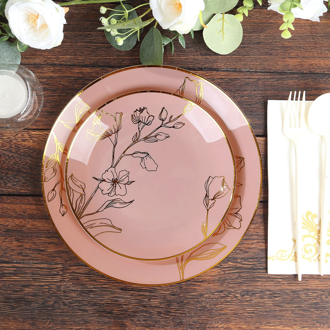 Elegant pink floral plates set on a rustic wooden table.