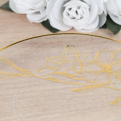 Gold floral design on clear glass plate with decorative white roses.