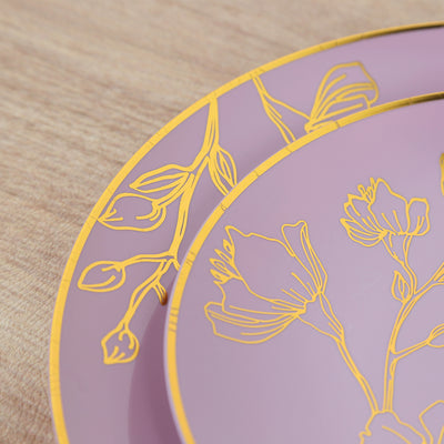 Elegant pink plate with gold floral design on wooden surface.