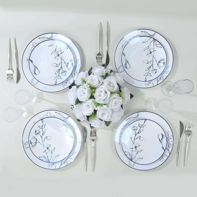 Floral dinner plates set with silverware and glassware on a table.