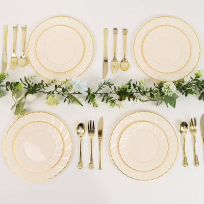 Elegant table setting with scalloped plates, gold cutlery, and floral accents.