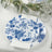 Decorative blue and white floral dinner plate with a napkin on a table setting.