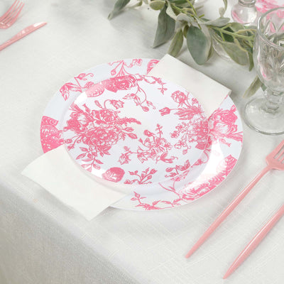 Pink floral patterned plate on a dining table setting.