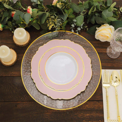 Elegant layered dinner plates with gold accents and greenery decor.