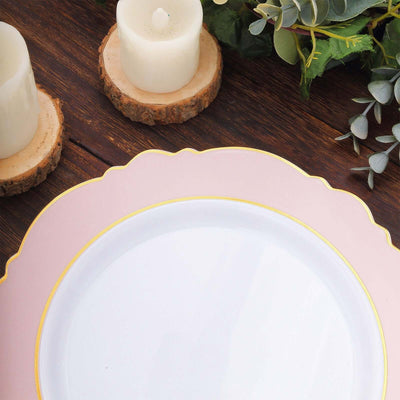 Elegant pink and gold trimmed dinner plate on rustic wooden table with candles.