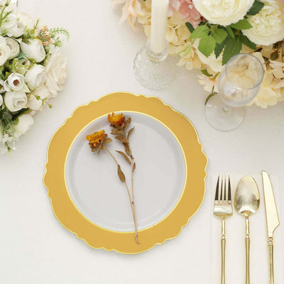 Elegant gold-rimmed plate with dried flower centerpiece on a beautifully set table.