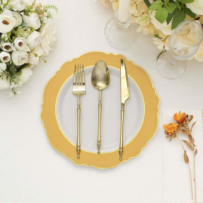 Elegant gold flatware set on a decorative plate with floral accents.