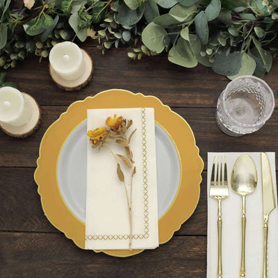 Elegant table setting with gold-accented plate, floral napkin, and utensils.