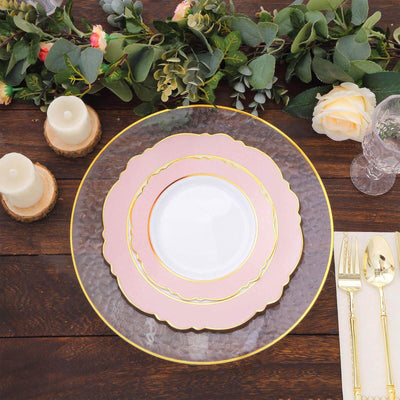Elegant pink and gray dinner plates with gold accents on a rustic wooden table.