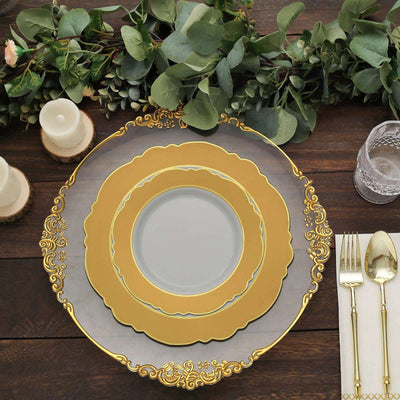 Elegant gold-rimmed dinner plate set on rustic wooden table with greenery.