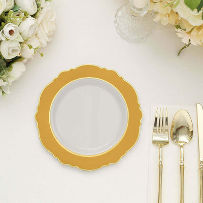 Elegant gold rimmed plate on a table setting with cutlery and floral decor.