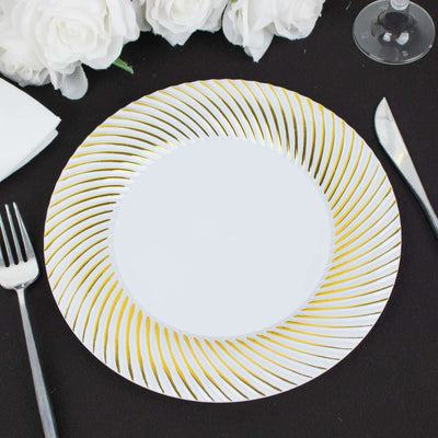 Elegant white plate with gold swirl design on a black table setting.