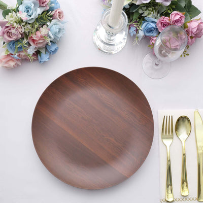 Elegant wooden dinner plate on a beautifully set table with flowers and cutlery.