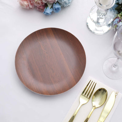 Brown wooden plate on a table setting with cutlery and floral decor.