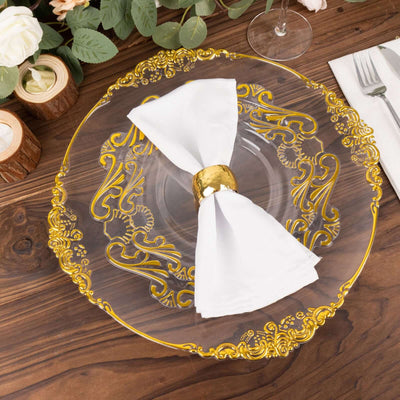 Elegant clear glass plate with gold ornate design and white napkin, styled for dining.