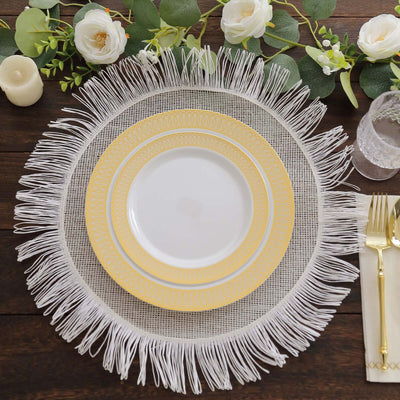 Elegant white and gold dinnerware set with decorative fringe on a wooden table.