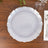 Elegant scalloped edge plate on wooden table setting.