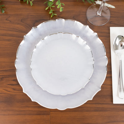 Silver-edged decorative plates stacked on a wooden table.