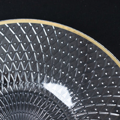 Decorative crystal plate with intricate diamond pattern and gold rim.