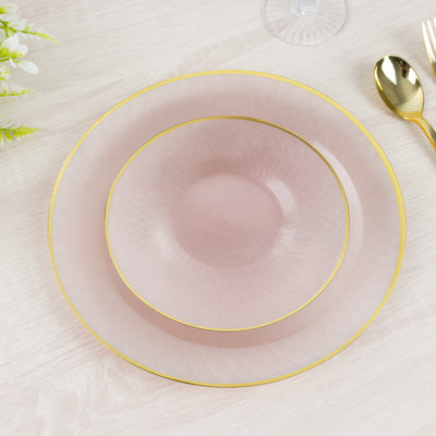 Elegant pink plates with gold rim on a light wooden surface.