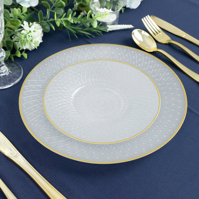 Elegant frosted glass plate with gold trim on a blue table setting.