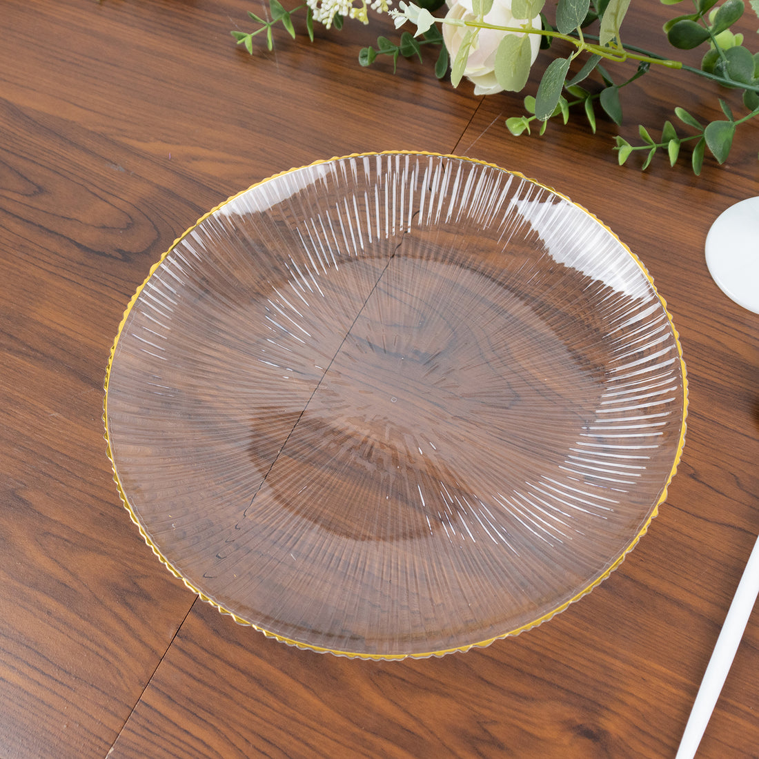 Clear glass plate with a decorative yellow rim on a wooden table.