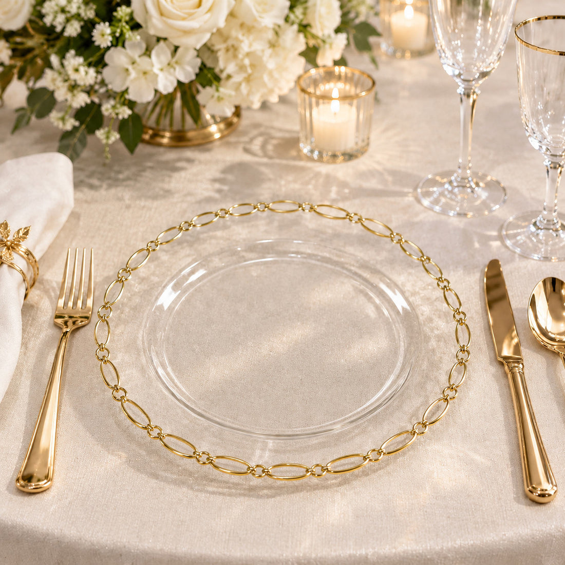 Elegant gold and glass wedding table setting with floral centerpiece and candles